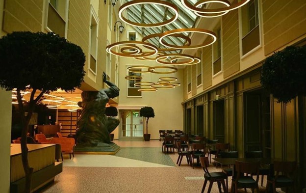 Corpuri de iluminat cu LED în formă de cerc amplasate în Hotel Atlas Timisoara deasupra meselor
